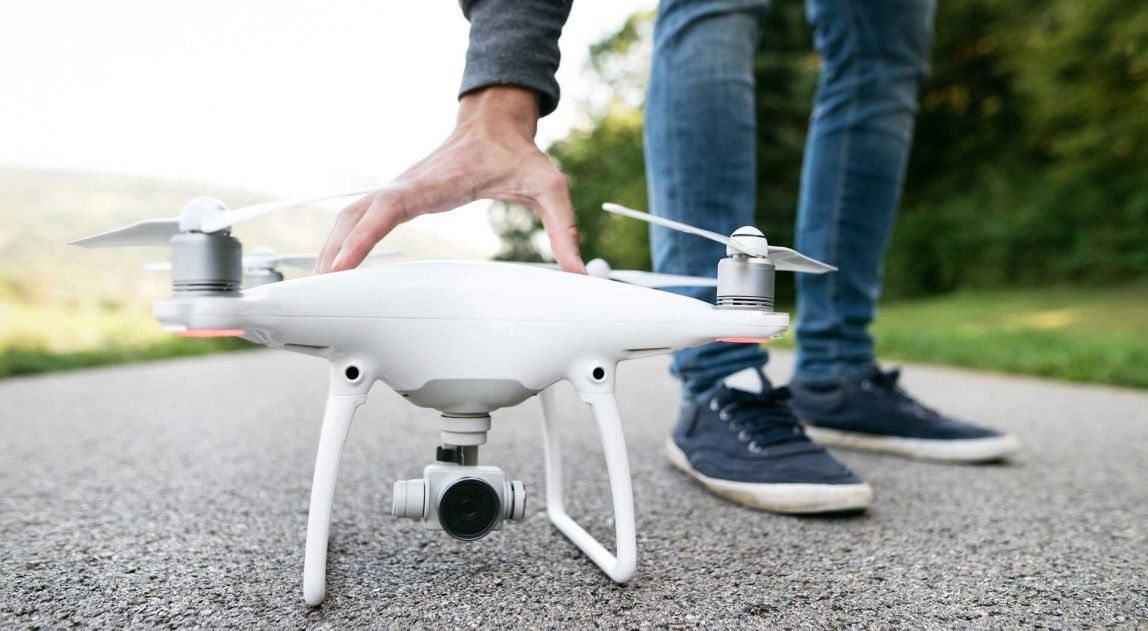 unrecognizable-man-with-drone-sunny-green-nature-c-PKFLLWC.jpg